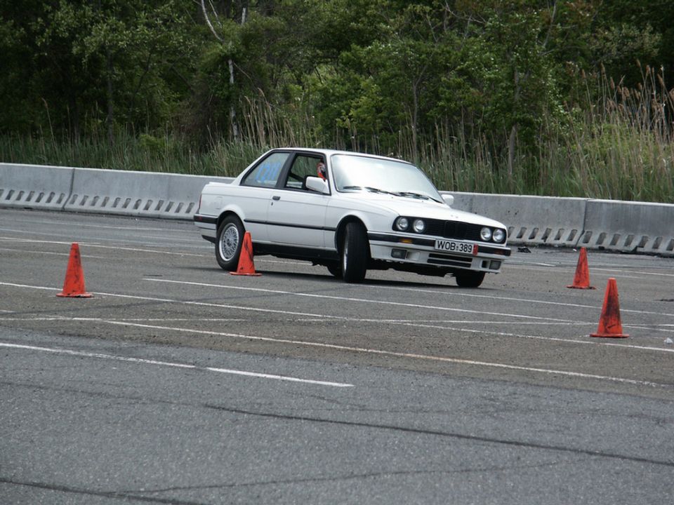 White BMW E30 coupe navigating autocross cones