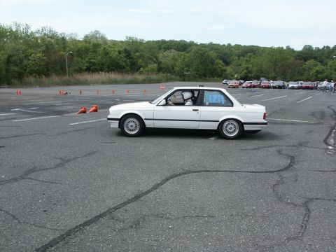 2001 Mercury Grand Marquis - A white BMW E30 coupe navigates an autocross course, with other vehicles and cones visible in the background.