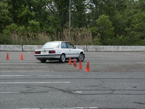 2001 Mercury Grand Marquis - White BMW E30 coupe is seen on an autocross course with orange cones.