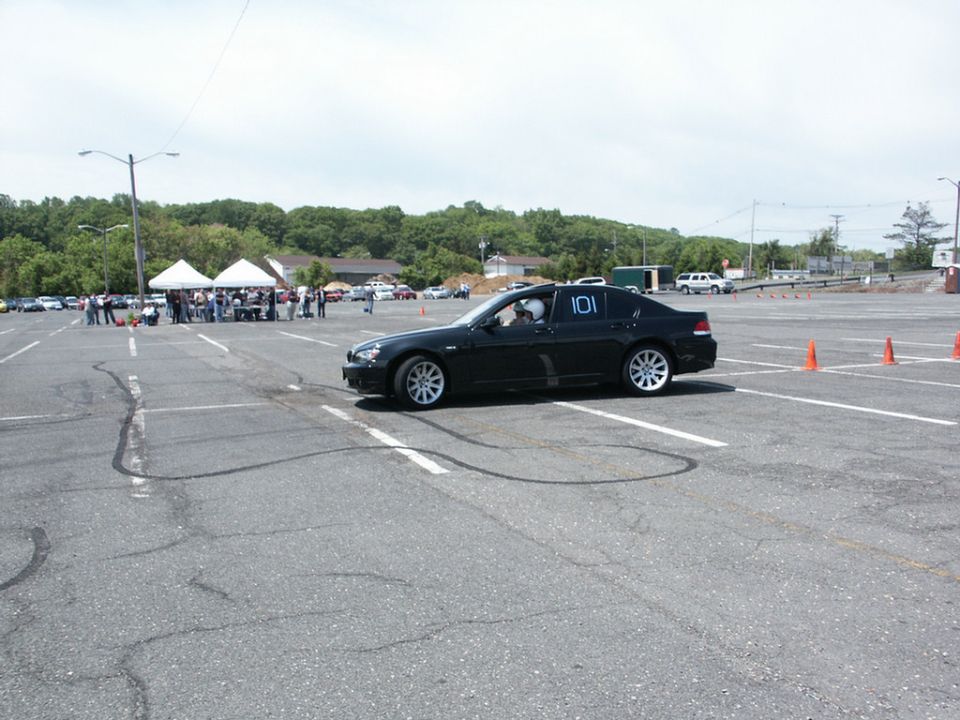 Black sedan with racing number 101 on door, parked in a lot with orange cones