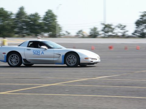 2001 Mercury Grand Marquis - A silver sports car with blue accents and racing numbers navigates a course marked by cones.