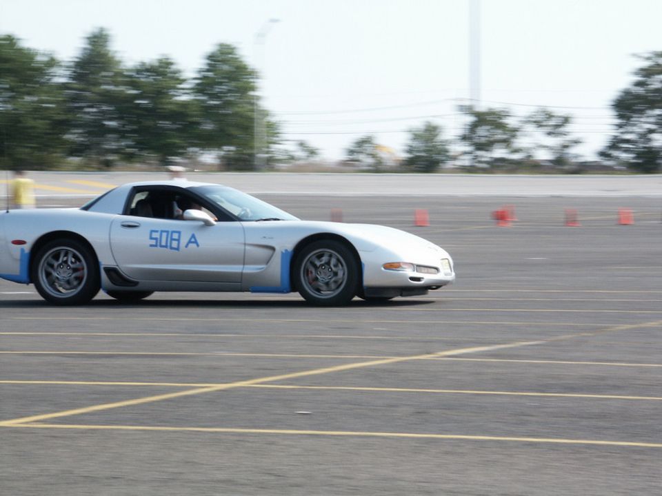 Silver sports car with blue racing stripes and '508 A' on the door, seen from the side