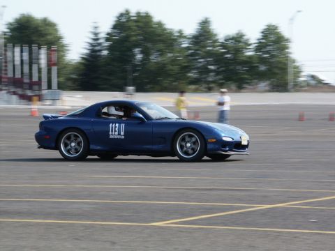 2001 Mercury Grand Marquis - A blue Mazda RX-7, identified by its racing number 113 U, navigates a track during an event.