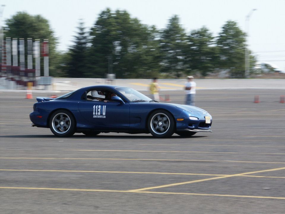 Blue Mazda RX-7 with racing number 113 U on the door, seen from the side