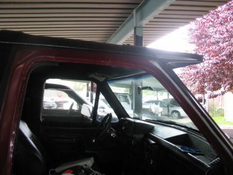 1991 Ford Bronco - View from inside a vehicle, showing the dashboard and side window with other cars visible outside.