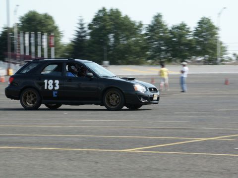 2001 Mercury Grand Marquis - A black station wagon with racing numbers navigates a track during an event.