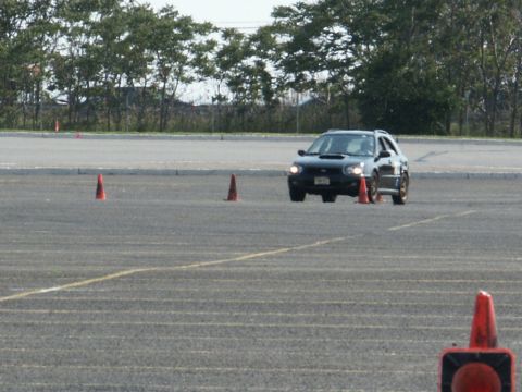 2001 Mercury Grand Marquis - A black Subaru Impreza WRX wagon navigates a course marked by orange cones on a paved lot.
