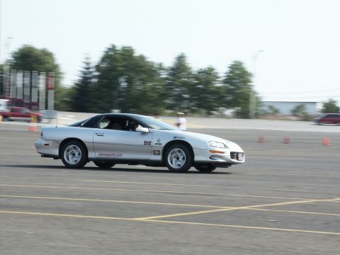 2001 Mercury Grand Marquis - Silver Chevrolet Camaro participating in a track event, showing racing decals and Hoosier branding.