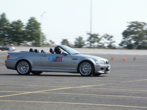 2001 Mercury Grand Marquis - Silver BMW M3 convertible with racing numbers on the door is seen on a track during an event.