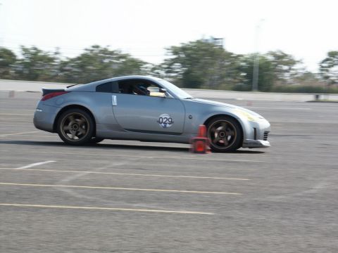 2001 Mercury Grand Marquis - Nissan 350Z on track, marked with number 029, navigating around orange cones.