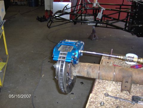 1978 Ford Bronco - A blue disc brake caliper is attached to a vehicle's rear axle, likely for a custom brake project.