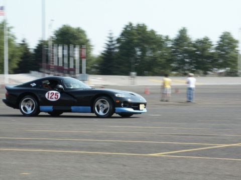 2001 Mercury Grand Marquis - A black sports car with blue accents and the number 125 is captured in motion on a track.