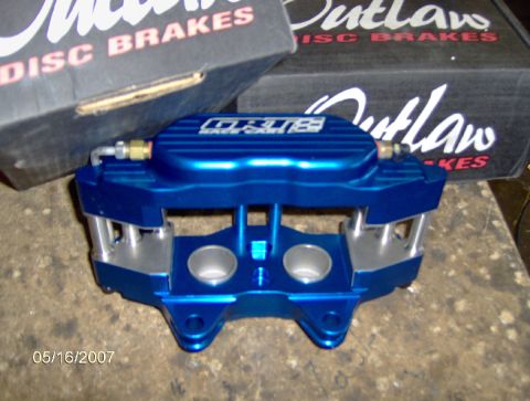 1978 Ford Bronco - A blue brake caliper is shown with "OUTLAW" branding, alongside "Outlaw Disc Brakes" packaging.
