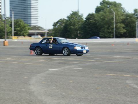 2001 Mercury Grand Marquis - Blue coupe with racing numbers on door driving on a paved track during an event.