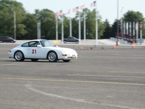 2001 Mercury Grand Marquis - A white Porsche 911 with racing number 21 is seen on a track, with American flags in the background.
