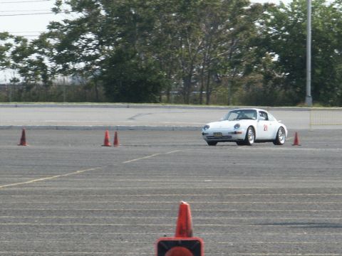 2001 Mercury Grand Marquis - A white Porsche 911 coupe navigates a course marked by orange cones.