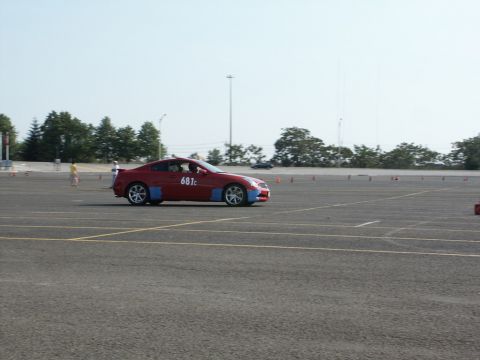 2001 Mercury Grand Marquis - A red coupe with blue fender flares and racing number 681 navigates a track during an event.