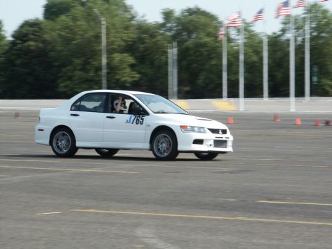 2001 Mercury Grand Marquis - A white Mitsubishi Lancer Evolution VIII, marked with A1765, navigates a track with cones and flags in the background.