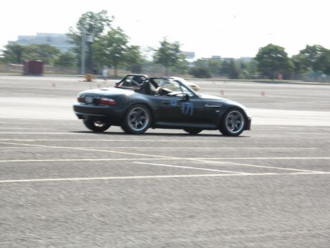 2001 Mercury Grand Marquis - A black convertible sports car with racing number 71 is seen on a track during an event.