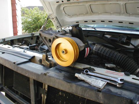 1996 Ford Bronco - Engine bay of a 1996 Ford Bronco showing a gold pulley and tools.