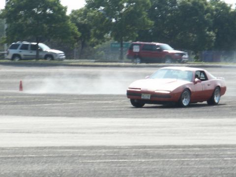 2001 Mercury Grand Marquis - A red sports car is seen drifting on a track, with other vehicles present.