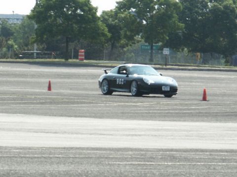 2001 Mercury Grand Marquis - A black Porsche 911, marked with the number 903, navigates a course marked by orange cones on a paved surface.
