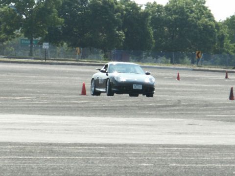 2001 Mercury Grand Marquis - Porsche 911 navigates a course marked by traffic cones on a sunny day.