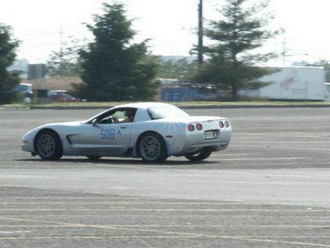 2001 Mercury Grand Marquis - Silver C5 Corvette with racing number 508 on the door is seen on a paved lot.