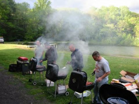 1991 Ford Bronco - Several men are gathered around grills cooking food outdoors, with smoke billowing into the air.