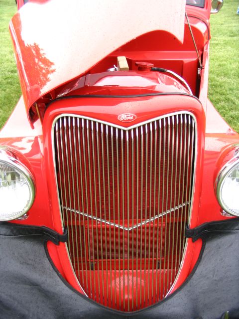 1993 Ford Taurus - A classic red Ford truck's front grille is shown with its hood open, revealing the engine compartment.