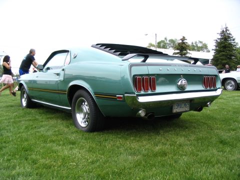 1993 Ford Taurus - A classic green 1969 Ford Mustang Mach 1 is displayed outdoors, with other vehicles visible in the background.