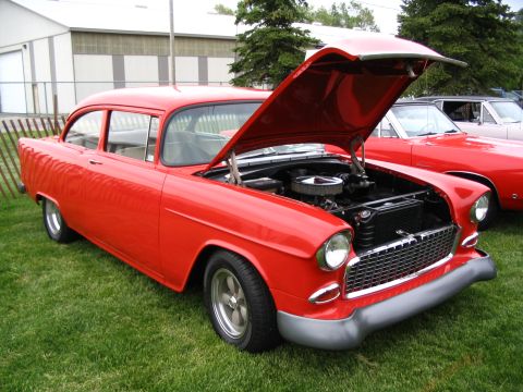 1993 Ford Taurus - A classic red 1955 Chevrolet Bel Air is displayed with its hood open at a car show.