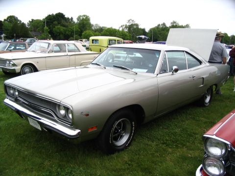 1993 Ford Taurus - A silver 1970 Plymouth Road Runner is displayed at a car show with its hood up.