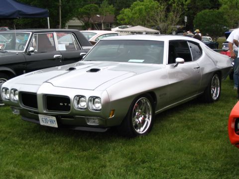 1993 Ford Taurus - A silver 1970 Pontiac GTO is displayed at an outdoor car show.