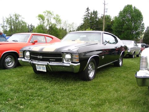 1993 Ford Taurus - A black 1970 Chevrolet Chevelle SS is parked on the grass at a car show, with other vehicles visible in the background.