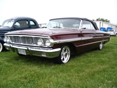 1993 Ford Taurus - A classic maroon Ford Galaxie convertible is displayed at an outdoor event with another vehicle nearby.