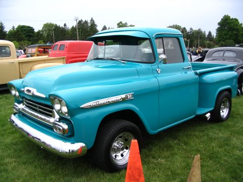1993 Ford Taurus - A turquoise 1955 Chevrolet Apache pickup truck is displayed at a car show.