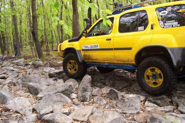 Yellow SUV with snorkel and off-road tires on a rocky trail