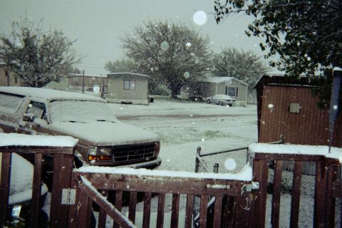 1996 Ford Bronco - A brown 1996 Ford Bronco sits covered in snow during a winter storm.