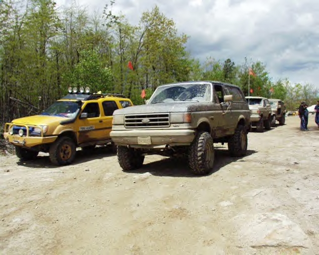 Gray 1987 Ford Bronco with large tires on a dirt road