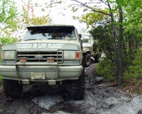 1991 Ford Bronco - A tan 1987 Ford Bronco is parked on a dirt path with another vehicle behind it.