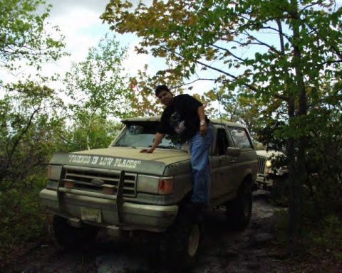 1991 Ford Bronco - Off-road scene with a Ford Bronco and a person. A Jeep is visible in the background.