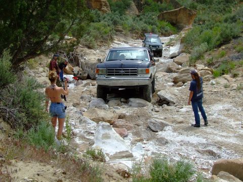1987 Ford Bronco - Off-roading adventure with a group of vehicles on a challenging rocky path.