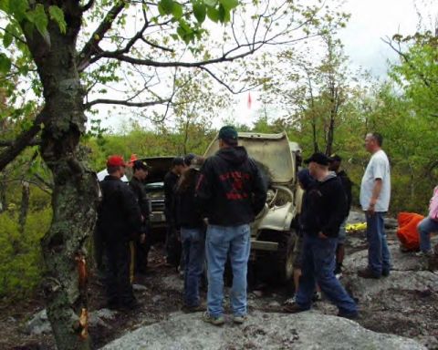 1991 Ford Bronco - Group of people gathered around a 1991 Ford Bronco in an outdoor setting.