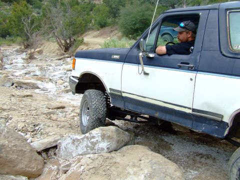 1987 Ford Bronco - Driver navigates a 1987 Ford Bronco through a rocky off-road trail.