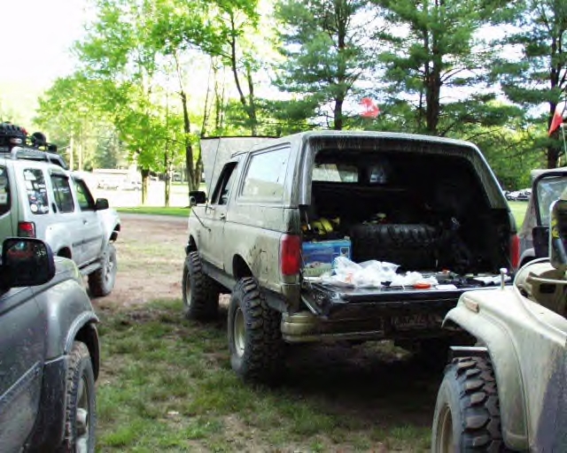 1991 Ford Bronco rear view, tailgate open, parked outdoors with other vehicles