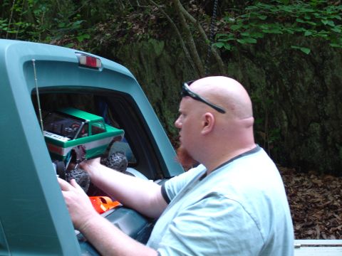 1996 Ford Bronco - A man places a remote control truck into the cargo area of an SUV.