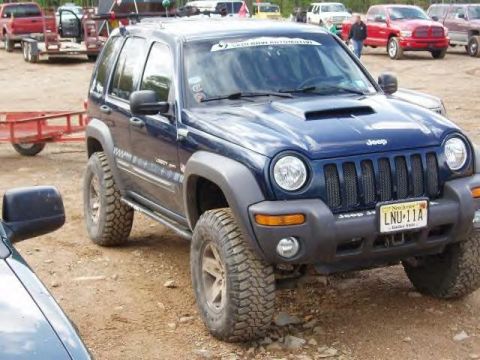 1991 Ford Bronco - A modified blue Jeep Liberty is shown with large off-road tires and a scoop on the hood.