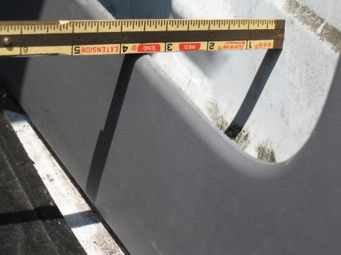 1994 Ford Bronco - A Lufkin steel tape measure laid across the top edge of a gray textured plastic panel to check a gap of roughly five inches against a white…