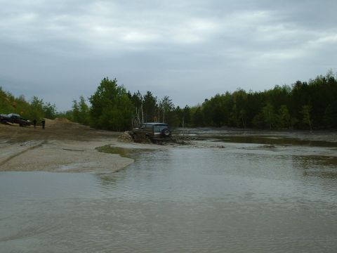 1991 Ford Bronco - Multiple off-road vehicles are seen traversing a challenging muddy and watery landscape.